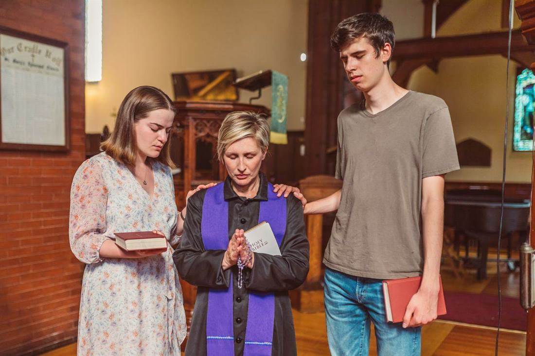 Grupo de pessoas reunidas em oração em uma igreja