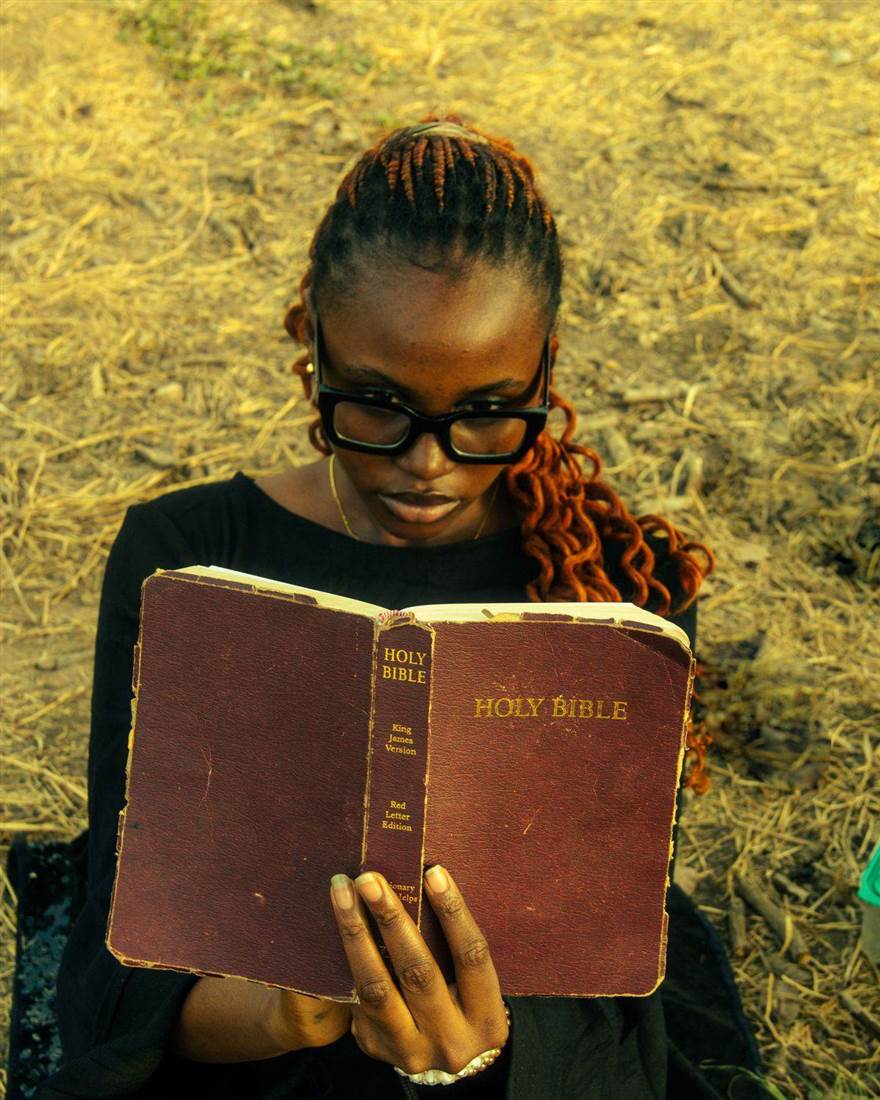 Mulher lendo uma Bíblia ao ar livre; foto ilustrativa, não do livro Devocional Mulheres 2027